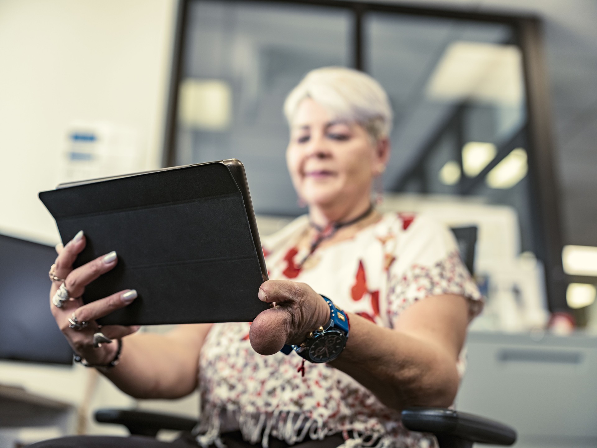 Femme latine handicapée utilisant une tablette au bureau